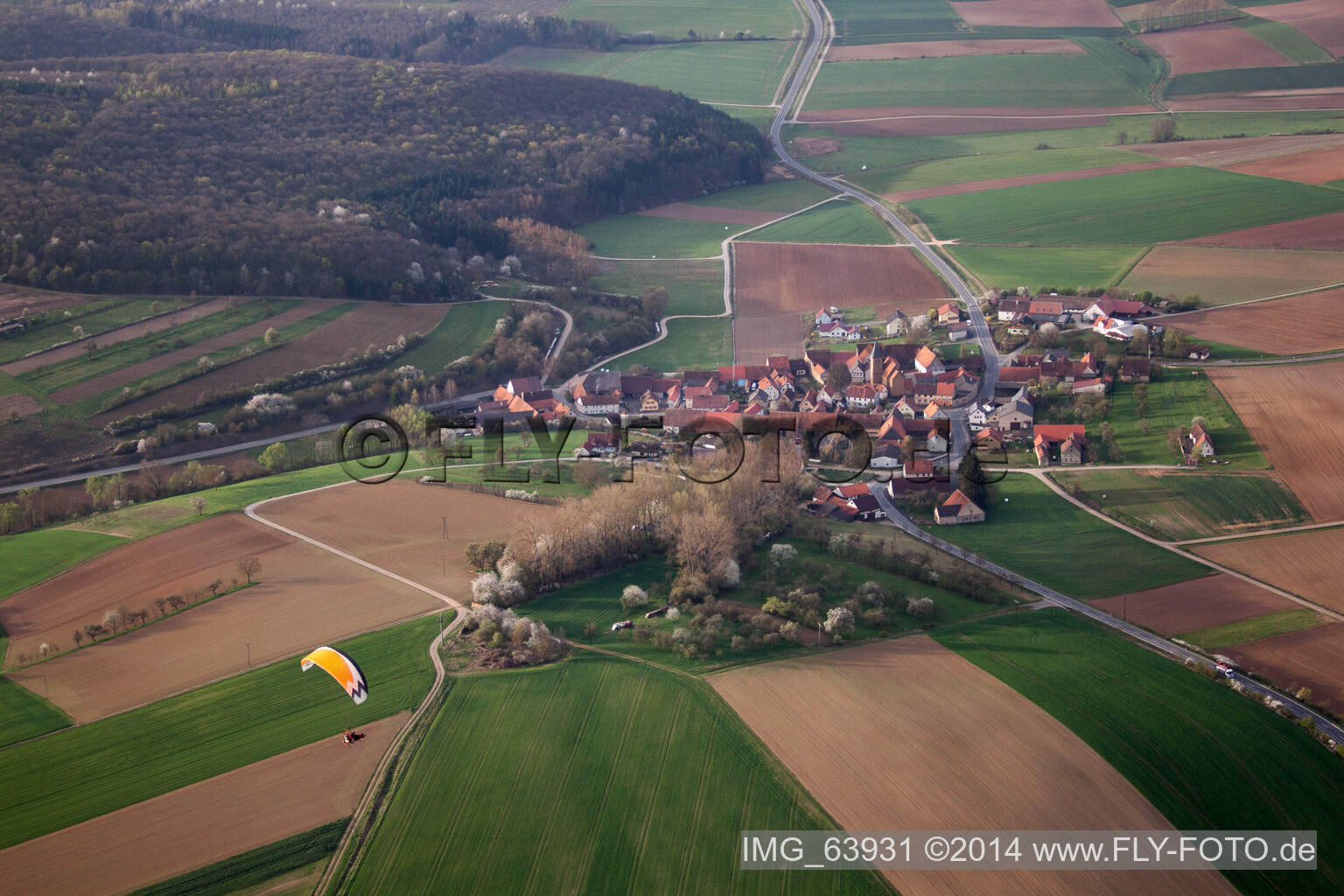 Dorf - Ansicht am Rande von landwirtschaftlichen Feldern und Nutzflächen in Junkershausen im Bundesland Bayern, Deutschland