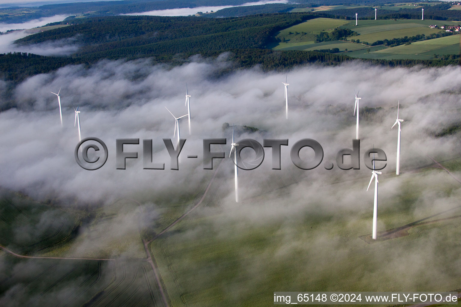 Wetterbedingt in eine Nebel- Schicht eingebettete Windenergieanlagen auf einem Feld im Ortsteil Fürstenau in Höxter im Bundesland Nordrhein-Westfalen, Deutschland