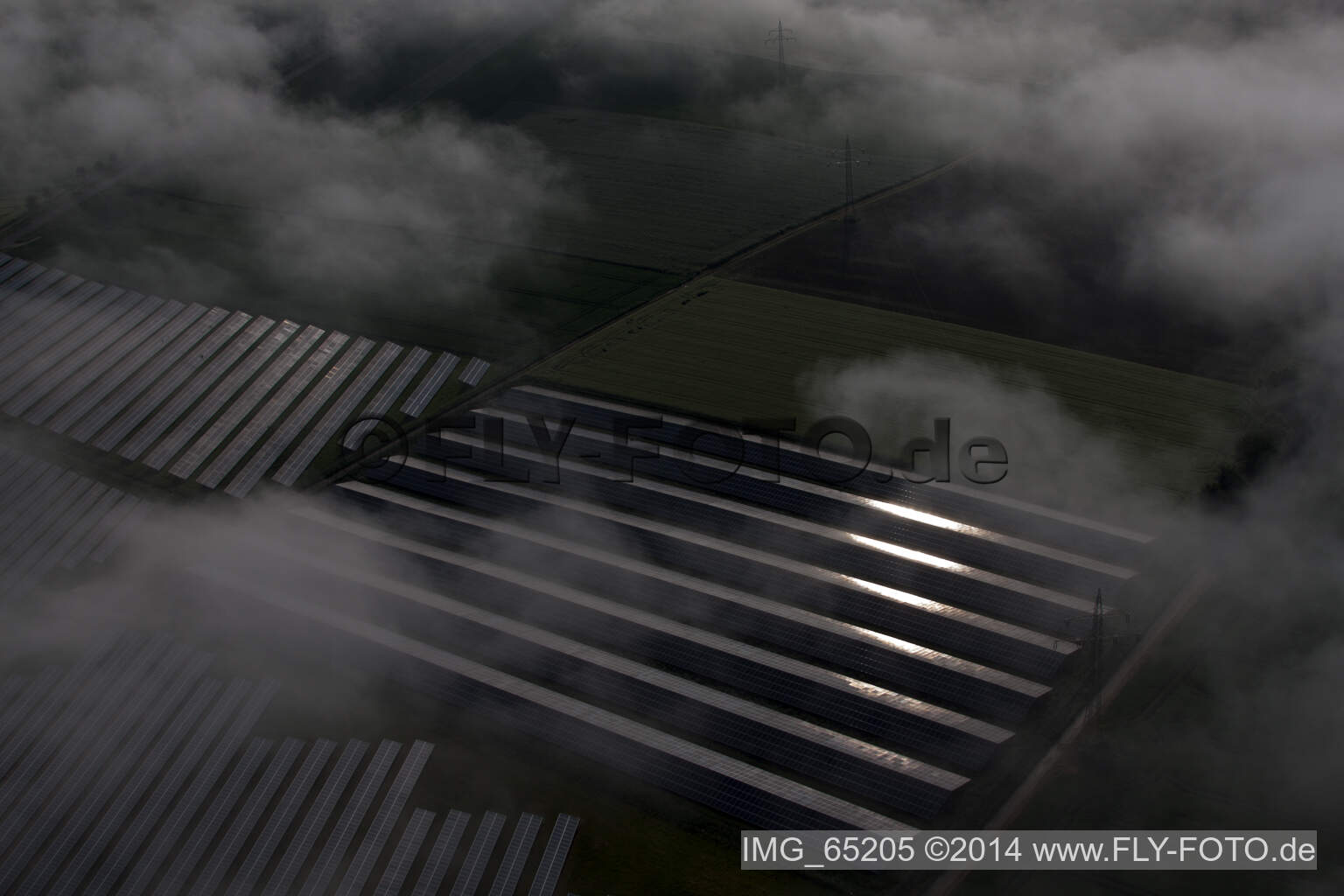 Wetterbedingt in eine Nebel- Schicht eingebettete Panelreihen der Photovoltaikanlage des Solarpark bzw. Solarkraftwerk im Ortsteil Bredenborn in Marienmünster im Bundesland Nordrhein-Westfalen, Deutschland von oben