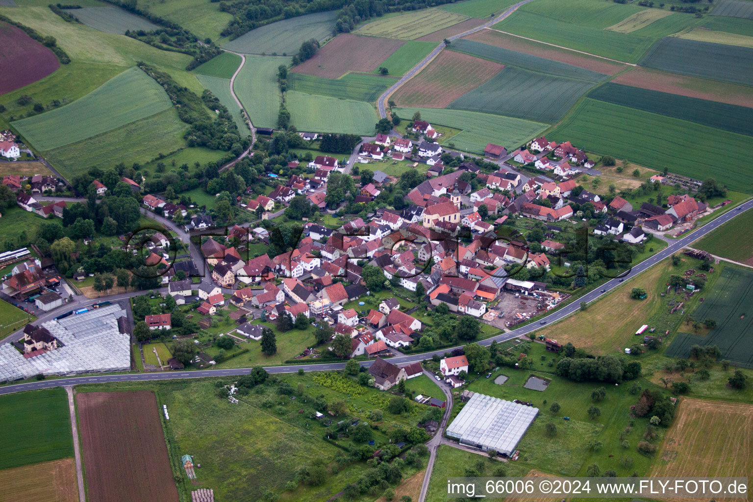 Dorf - Ansicht am Rande von landwirtschaftlichen Feldern und Nutzflächen in Karsbach im Bundesland Bayern, Deutschland