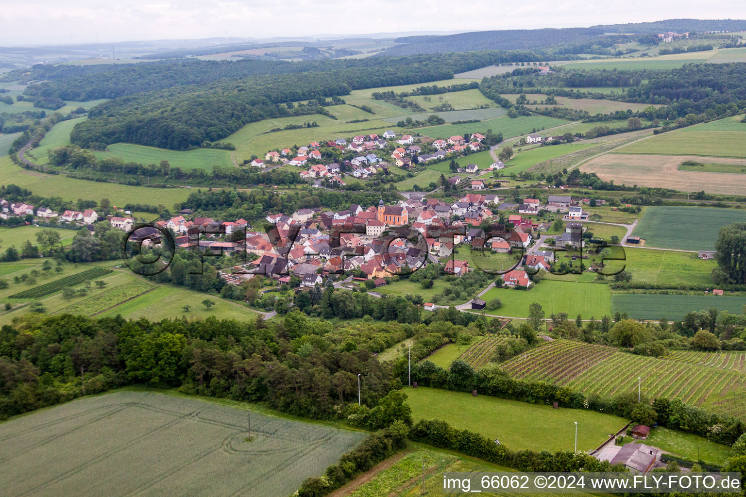 Dorf - Ansicht am Rande von landwirtschaftlichen Feldern und Nutzflächen im Ortsteil Reuchelheim in Arnstein im Bundesland Bayern, Deutschland