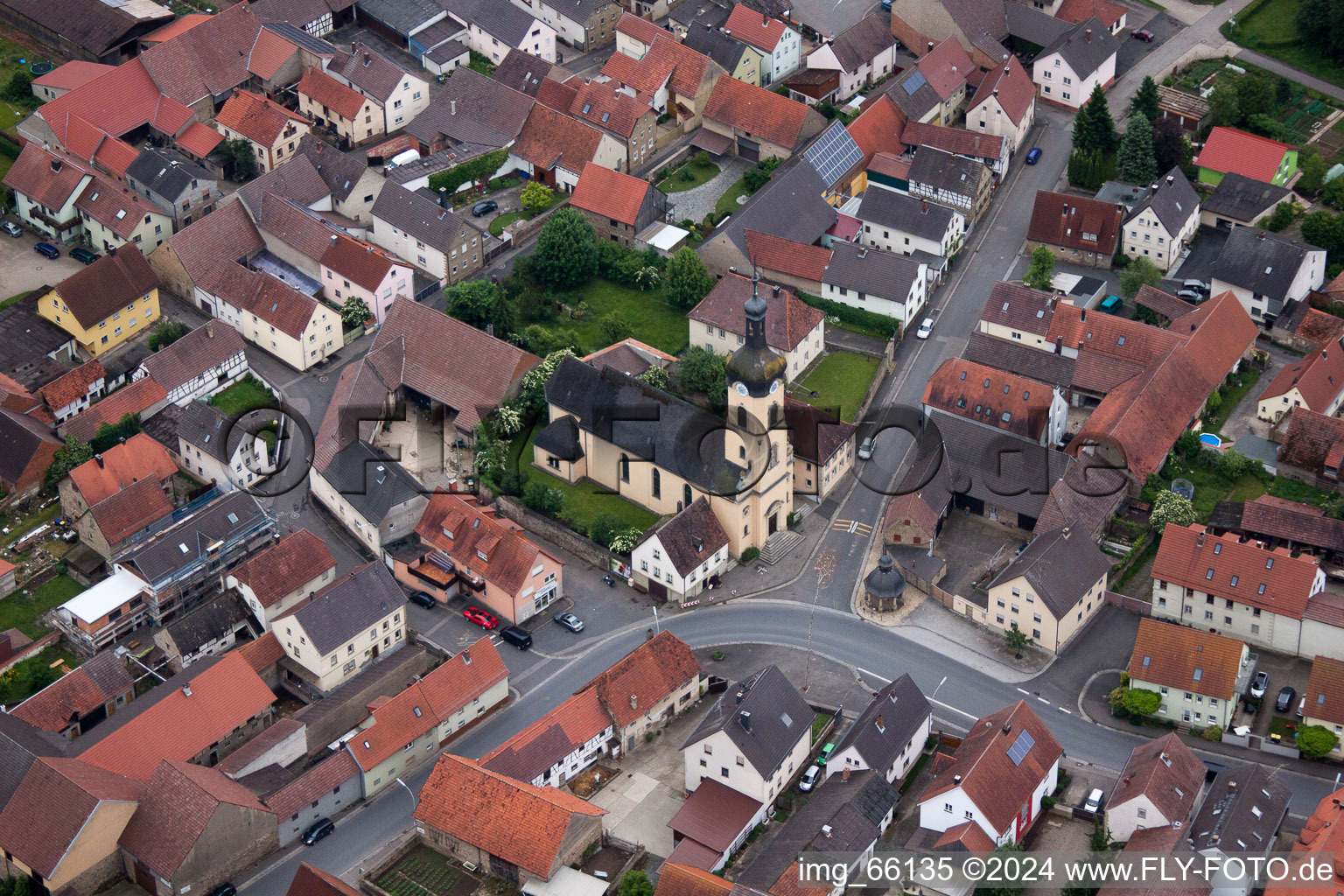 Luftbild von Kirchengebäude im Dorfkern in Werneck im Bundesland Bayern, Deutschland