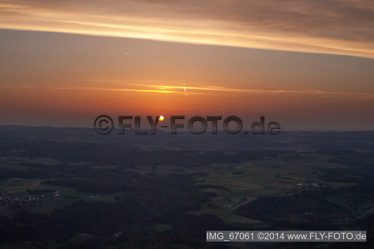 Luftaufnahme von Sonnenuntergang färbt den Himmel über der Landschaft in Ehingen (Donau) rot orange im Bundesland Baden-Württemberg, Deutschland