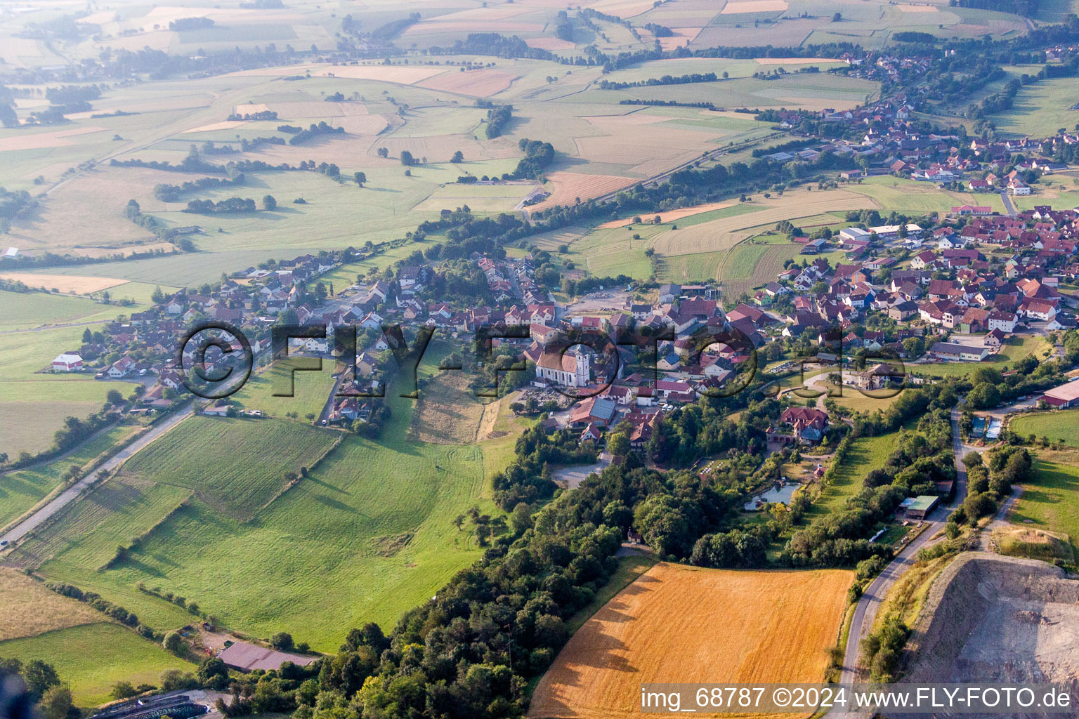 Dorf - Ansicht am Rande von landwirtschaftlichen Feldern und Nutzflächen in Oberleichtersbach im Bundesland Bayern, Deutschland
