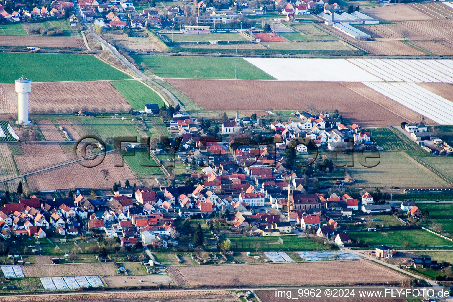 Dorf - Ansicht am Rande von landwirtschaftlichen Feldern und Nutzflächen in Lustadt im Bundesland Rheinland-Pfalz, Deutschland