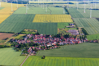 Windräder einer Windkraftwerks- Anlage auf landwirtschaftlichen Nutzflächen und Feldern am Rande des Siedlungsgebiet des Dorfes in Hochheim in Nessetal im Bundesland Thüringen, Deutschland