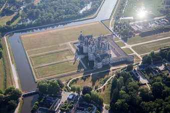 Schrägluftbild von Gebäudekomplex im Schloßpark von Schloß Château de Chambord in Chambord in Centre-Val de Loire im Bundesland Loir-et-Cher, Frankreich