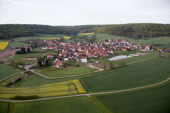 Dorf - Ansicht am Rande von landwirtschaftlichen Feldern und Nutzflächen in Geusfeld bei Rauhenebrach im Bundesland Bayern, Deutschland