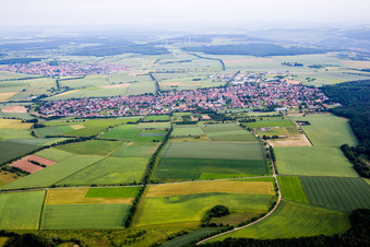 Dorf - Ansicht am Rande von landwirtschaftlichen Feldern und Nutzflächen in Waldbüttelbrunn im Bundesland Bayern, Deutschland