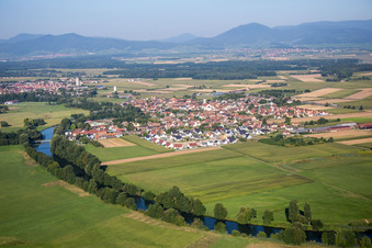 Dorfkern an den Fluß- Uferbereichen des Ill vor dem Panorama des Vogesenrandes in Sermersheim in Grand Est im Bundesland Bas-Rhin, Frankreich