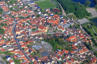 Ortszentrum mit Kirche St. Nikolaus Sand am Main und Gewächshäuser von Blumen Zösch im Bundesland Bayern, Deutschland