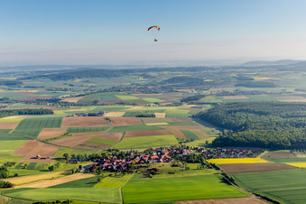 Paraglider über der Ortschaft im Ortsteil Altenmünster in Stadtlauringen im Bundesland Bayern, Deutschland