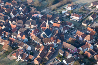 Luftaufnahme von Gebäude der von einem Häuserring umgebenen lutherisch-protestantischen Wehrkirche im Dorfkern in Dossenheim-sur-Zinsel in Grand Est im Bundesland Bas-Rhin, Frankreich