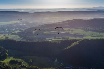 Wald und Berglandschaft mit 3 Paragleitern im Weserbergland in Holenberg im Bundesland Niedersachsen, Deutschland