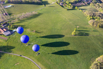 Luftaufnahme von Drei blaue Heißluftballone beim Start in der Dordogne in Veyrines-de-Domme in Nouvelle-Aquitaine, Frankreich