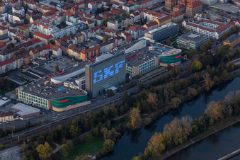 Luftbild von Gebäude des Einkaufszentrum Stadtgalerie Schweinfurt und am Abend beleuchtetes SKF Hochhaus in Schweinfurt im Ortsteil Grün im Bundesland Bayern, Deutschland