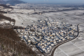 Winterlich schneebedeckte Dorf - Ansicht am Rande von Weinbergen zu Füßen des Haardtrandes des Pfälzerwalds in Eschbach im Bundesland Rheinland-Pfalz, Deutschland