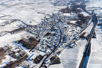 Winterlich schneebedeckte Ortsansicht der Straßen und Häuser der Wohngebiete in Siebeldingen im Bundesland Rheinland-Pfalz, Deutschland