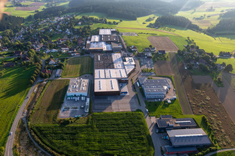 Luftaufnahme von Gebäude und Produktionshallen auf dem Werksgelände der Saier Verpackungstechnik in Alpirsbach im Ortsteil Peterzell im Bundesland Baden-Württemberg, Deutschland