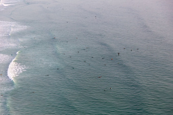 Auf die Welle wartende Surfer vor dem Plage de Tronoën in Saint-Jean-Trolimon im Bundesland Finistère, Frankreich