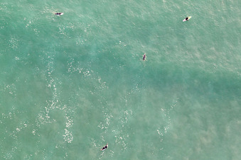 Luftaufnahme von Auf die Welle wartende Surfer vor dem Plage de Tronoën in Saint-Jean-Trolimon im Bundesland Finistère, Frankreich