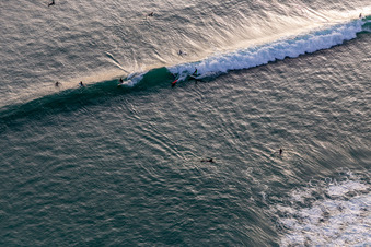 Schrägluftbild von Wellensurfer vor dem Plage de Tronoën in Saint-Jean-Trolimon im Bundesland Finistère, Frankreich