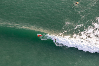 Wellensurfer vor dem Plage de Tronoën in Saint-Jean-Trolimon im Bundesland Finistère, Frankreich aus der Vogelperspektive
