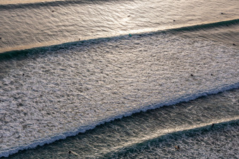 Wellensurfer vor dem Plage de Tronoën in Saint-Jean-Trolimon im Bundesland Finistère, Frankreich aus der Drohnenperspektive