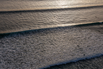 Wellensurfer vor dem Plage de Tronoën in Saint-Jean-Trolimon im Bundesland Finistère, Frankreich von einer Drohne aus