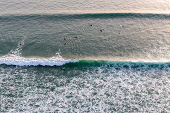 Wellensurfer vor dem Plage de Tronoën in Saint-Jean-Trolimon im Bundesland Finistère, Frankreich von der Drohne aus gesehen