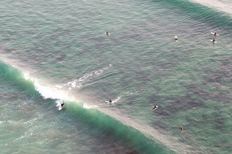 Luftaufnahme von Wellensurfer vor dem Plage la Torche-Tronoën in Saint-Jean-Trolimon im Bundesland Finistère, Frankreich