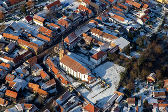 Hauptstraße mit Pfarrkirche St. Michael im Winter bei Schnee in Rheinzabern im Bundesland Rheinland-Pfalz, Deutschland aus der Luft