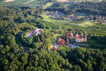 Schrägluftbild von Kirche Župnijska cerkev sv. Marije Vnebovzete und Café Huda Liza auf dem Vurberg in Duplek, Slowenien