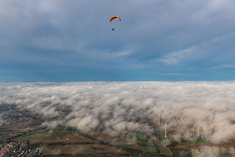 Paragleiter überm Windpark Freckenfeld in Wolken im Bundesland Rheinland-Pfalz, Deutschland