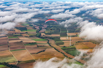 Paragleiter über dem Windpark Freckenfeld in Wolken im Bundesland Rheinland-Pfalz, Deutschland