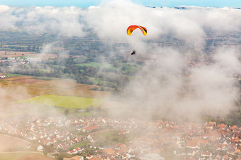 Luftbild von Ortschaft mit Gleitschirm unter herbstlichen Wolken in Steinweiler im Bundesland Rheinland-Pfalz, Deutschland