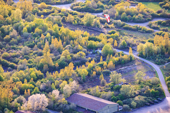 Paraglider über den Hangars am ehemaligen Miltärflugplatz Grostenquin in Bistroff im Bundesland Moselle, Frankreich