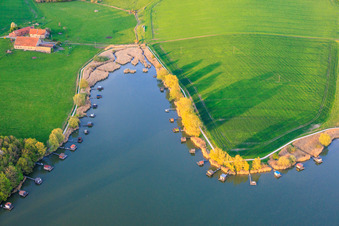 Stege mit Anglerhütten umsäumen das Ufer des Sees Etang du Welschhof in Puttelange-aux-Lacs im Bundesland Moselle, Frankreich