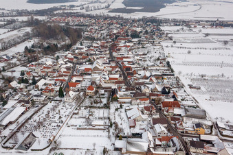 Winterlich schneebedeckte Dorf - Ansicht am Rande von landwirtschaftlichen Feldern und Nutzflächen in Winden im Bundesland Rheinland-Pfalz, Deutschland