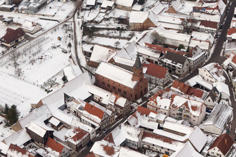 Winterlich schneebedeckte Kirchengebäude der evangelischen Kirche in der Dorfmitte in Steinweiler im Bundesland Rheinland-Pfalz, Deutschland