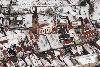 Luftbild von Winterlich schneebedeckte Kirchengebäude der katholischen Kirche in der Dorfmitte in Steinweiler im Bundesland Rheinland-Pfalz, Deutschland