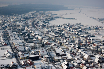Winterlich schneebedeckte Dorf - Ansicht am Rande von landwirtschaftlichen Feldern und Nutzflächen in Hatzenbühl im Bundesland Rheinland-Pfalz, Deutschland