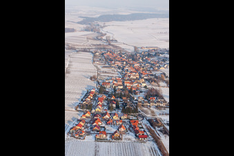 Winterlich schneebedeckte Dorf - Ansicht am Rande von landwirtschaftlichen Feldern und Nutzflächen in Niederhorbach im Bundesland Rheinland-Pfalz, Deutschland