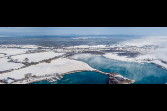 Panorama Perspektive Winterlich schneebedeckte Ortsansicht der Straßen und Häuser der Wohngebiete hinter Baggerseen in Lauterbourg in Grand Est im Ortsteil Neulauterburg im Bundesland Bas-Rhin, Frankreich