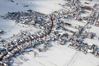 Winterlich schneebedeckte Kirchengebäude im Dorfkern in Schleithal in Grand Est im Bundesland Bas-Rhin, Frankreich