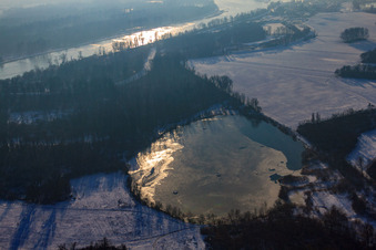 Gefrorener Baggersee bei Schnee im Winter in Lauterbourg im Bundesland Bas-Rhin, Frankreich