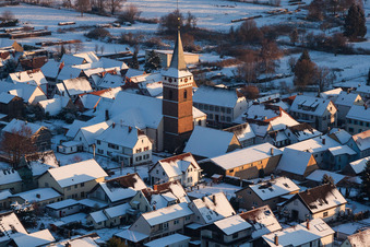 Winterlich schneebedeckte Kirchengebäude im Dorfkern im Ortsteil Schaidt in Wörth am Rhein im Bundesland Rheinland-Pfalz, Deutschland