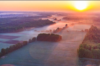 Sonnenaufgang über der Otterbachniederung im Morgendunst in Minfeld im Bundesland Rheinland-Pfalz, Deutschland