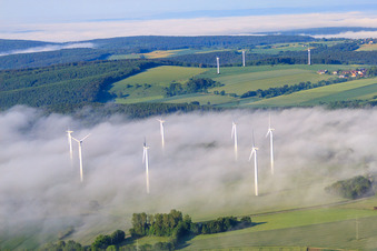 Rotoren des Windpark Fürstenau ragen aus tiefen Wolken heraus in Höxter im Bundesland Nordrhein-Westfalen, Deutschland