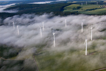 Wetterbedingt in eine Nebel- Schicht eingebettete Windenergieanlagen auf einem Feld im Ortsteil Fürstenau in Höxter im Bundesland Nordrhein-Westfalen, Deutschland